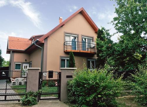 a house with a balcony and a fence at Lavender Apartment in Siófok
