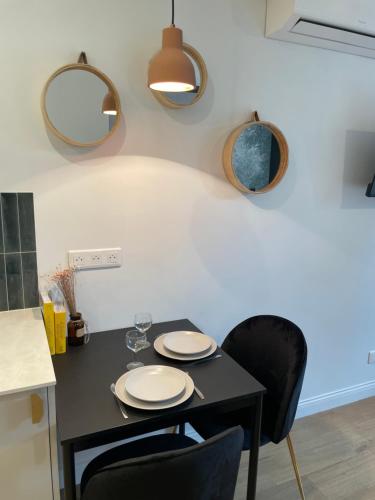 a black table with two chairs and two mirrors at L'Adresse Studio Rempart sud - centre historique Eguisheim in Eguisheim