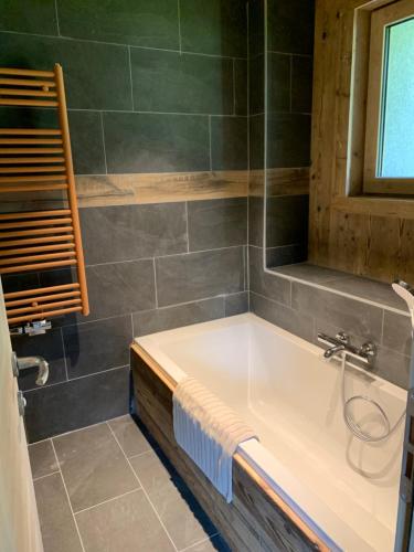 une salle de bain avec une baignoire et une fenêtre dans l'établissement Chalet BELLAVISTA, à Chamonix-Mont-Blanc