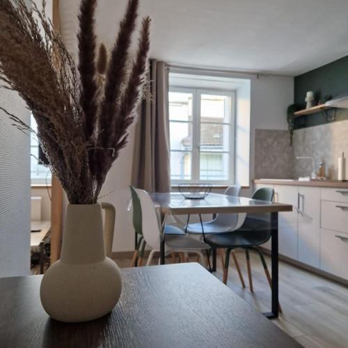 une table avec un vase sur une table dans l'établissement Studio Rue Carnot Le St Pierre, à Mâcon