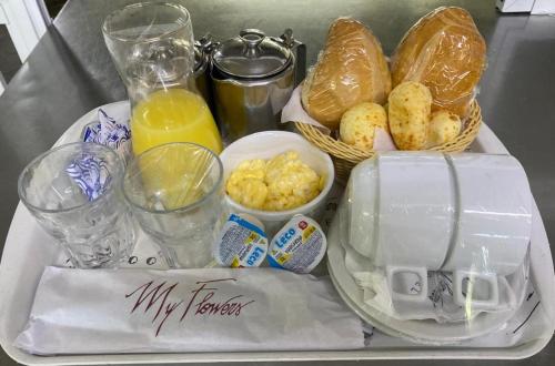 una bandeja de comida con pan y bebidas en una mesa en Motel My Flowers, en São Paulo