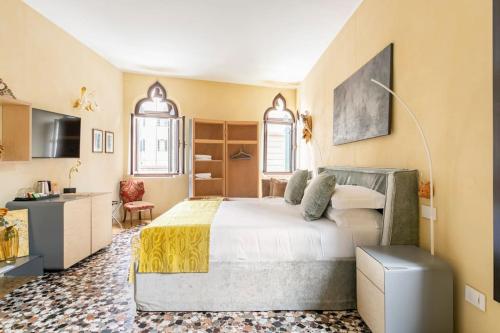 a bedroom with a large bed and a kitchen at Cinqueteste Luxury Home in Venice