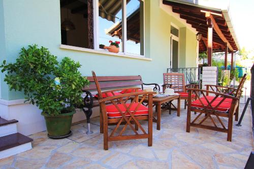 un patio con mesa, sillas y una planta en Apartments Tomi & Ivana, en Trogir