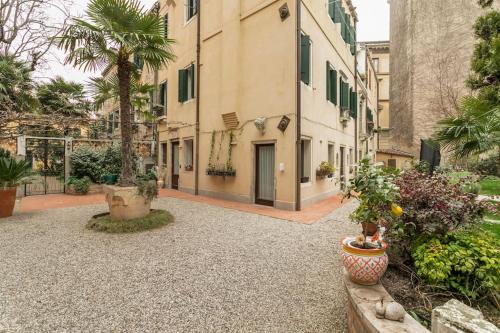 Cinqueteste Luxury Home في البندقية: ساحة مع نباتات الفخار ومبنى