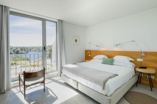 a bedroom with a bed and a large window at Vale do Gaio Hotel in Torrão