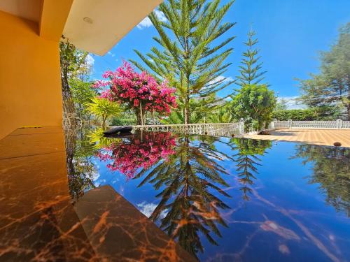 a pool of water with pink flowers and trees at Villa Concepción Lodge in Anta