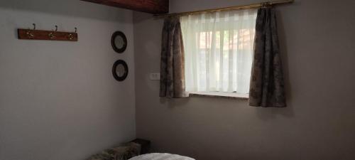 a bedroom with a window with curtains and a bed at Begova kuća-Velika Kladuša in Velika Kladuša