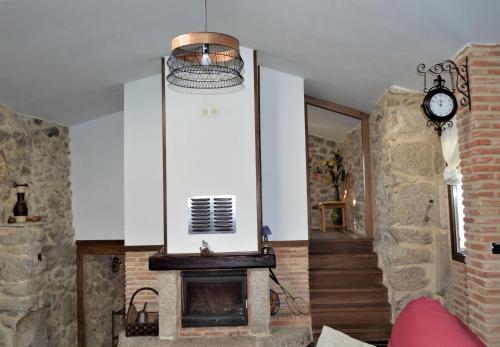 a living room with a fireplace and a clock at Airiños de Mondariz in Mondariz