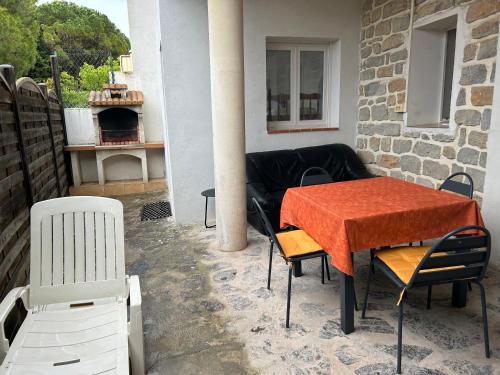 un patio avec une table, des chaises et un canapé dans l'établissement Sirmione, à Leucate