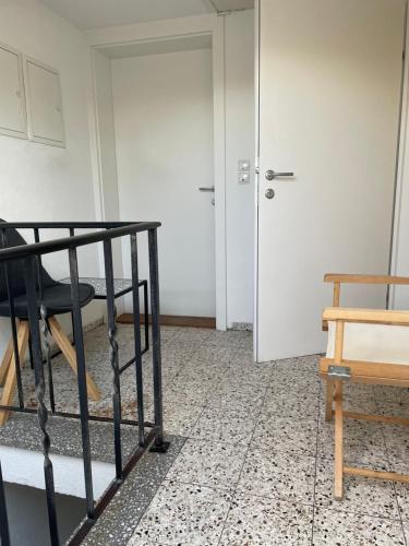 a room with a bed and a door and a table at Small attic apartment close to Lake and Mountains Fussach in Fußach