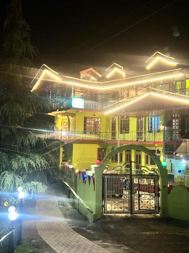 a large yellow building at night with a bridge at SummerHill Riverview Homestay in Sainj