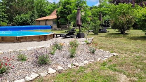 - une piscine dans une cour avec des chaises et un parasol dans l'établissement Gite Pech d escars Ancienne maison avec piscine, à Quissac