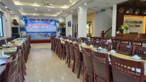 Tan Truong Son Legacy Hotel في سام سون: صف من الطاولات والكراسي في قاعة احتفالات