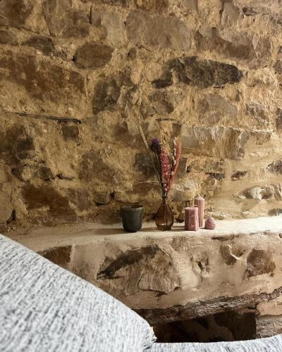 un mur de pierre avec un vase de fleurs sur un rebord dans l'établissement Le Moulin de Blanchelande, à Neufmesnil