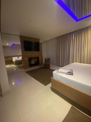 a hotel room with a bed and a tv at Motel My Flowers 4 in São Paulo