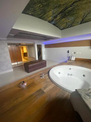 a large bathroom with a bath tub and a couch at Motel My Flowers 4 in São Paulo
