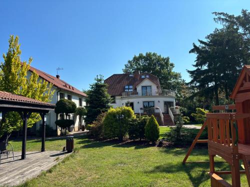 a large white house with a yard at Pokoje Gościnne Świnoujście Łunowo in Świnoujście