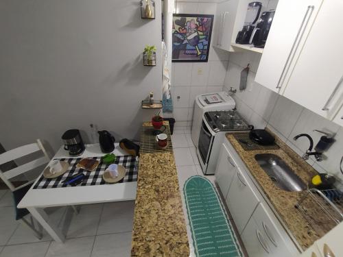 una pequeña cocina con fogones y fregadero en Solar do Pontal - Lindo Apartamento a 600m da praia, en Río de Janeiro
