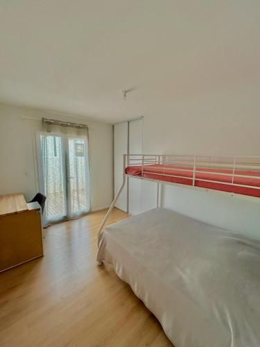 une chambre avec un lit superposé et une fenêtre dans l'établissement Villa Sévina 700m valras plage, à Sérignan