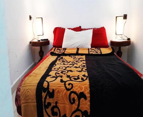 薩菲的住宿－Welcome to a small apartment near Ras El Lefa Beach，一间卧室配有一张带两盏灯的床。
