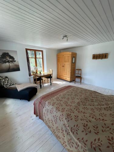 sypialnia z dużym łóżkiem i stołem w obiekcie Maison Bardoz w mieście Le Clerjus