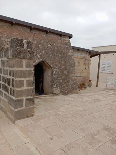 a brick building with a doorway in a patio at Casolare Giardino Aiarella-Assunta in Merine