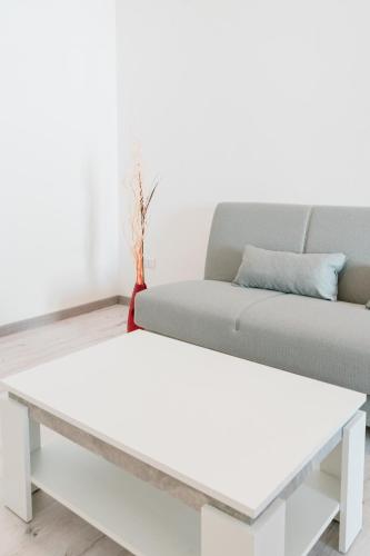 a white coffee table in a living room with a couch at FG Vacanze in Alghero