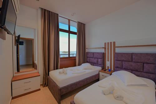 Habitación de hotel con 2 camas y ventana en Hotel Meta Ksamil, en Ksamil