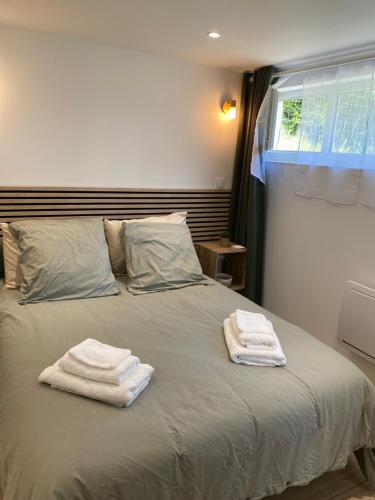 two towels sitting on top of a bed at Dune et Terrasse in Merville-Franceville-Plage