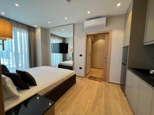 a bedroom with a large bed and a large mirror at Coastline Luxury Apart Hotel in Golem
