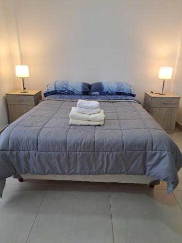 Una cama con dos lámparas y dos toallas. en DEPARTAMENTO DEL SUR en Ushuaia