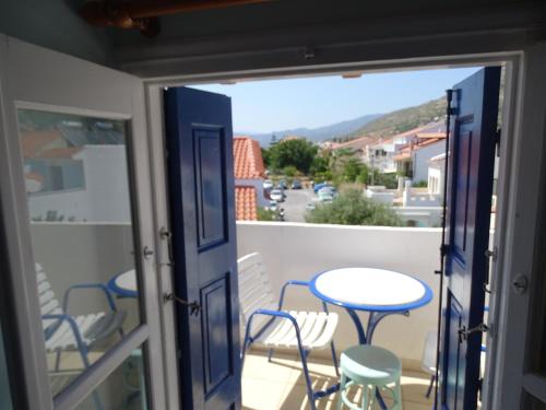 a room with a balcony with a table and chairs at Hotel Mariona in Pythagoreio