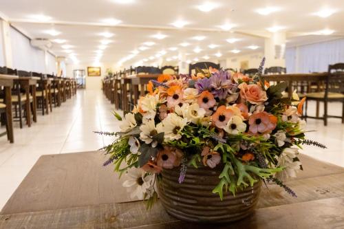 a bouquet of flowers in a basket on a table at Rede Andrade Mirante in Foz do Iguaçu