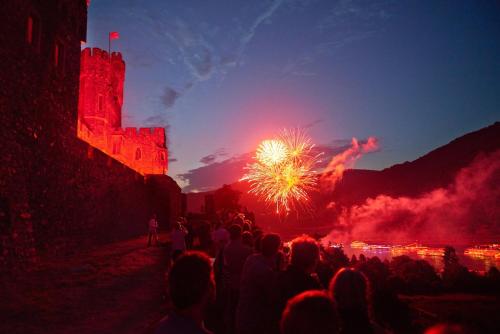 a crowd of people watching a fireworks show with a castle at Burg Reichenstein in Trechtingshausen