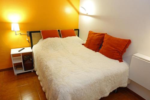 - une chambre dotée d'un lit avec des oreillers orange dans l'établissement Plein Sud, à Cassis
