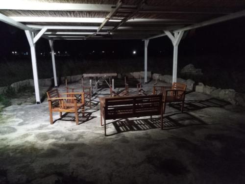 a group of chairs and tables under a pavilion at night at Casolare Giardino Aiarella-Assunta in Merine