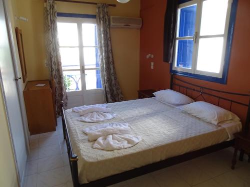a bedroom with two towels on a bed with a window at Hotel Mariona in Pythagoreio