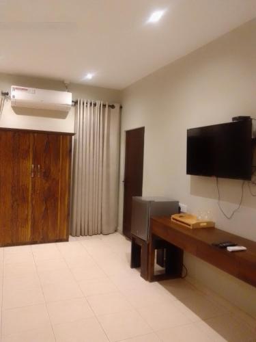 a room with a desk and a flat screen tv at Beach Front by Kay Jay in Uswetakeiyawa