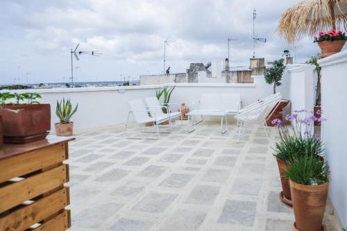a balcony with a table and chairs on a building at Sea Suites in Ugento