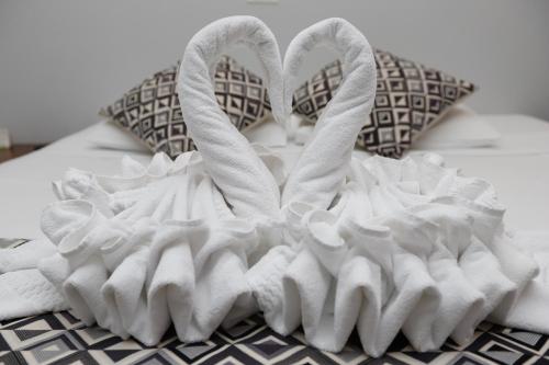 a pair of towel swans sitting on a bed at Rede Andrade Mirante in Foz do Iguaçu