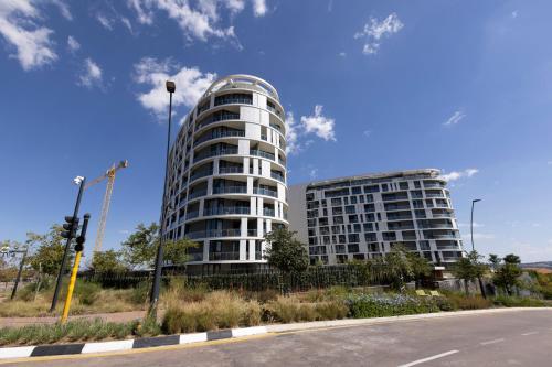 two tall white buildings on the side of a street at The Executive Apartment in Ellipse Waterfall City in Midrand