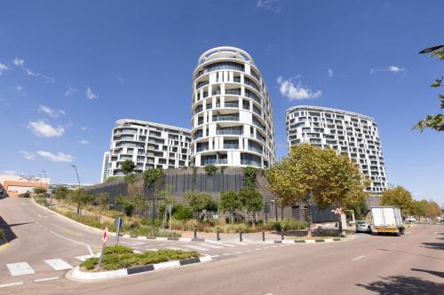 two tall white buildings on a city street at The Executive Apartment in Ellipse Waterfall City in Midrand