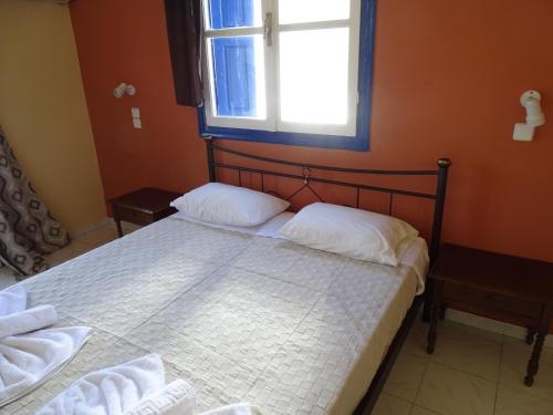 a bedroom with a large bed with a window at Hotel Mariona in Pythagoreio
