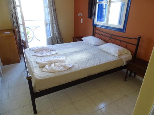 a bedroom with a bed with two towels on it at Hotel Mariona in Pythagoreio