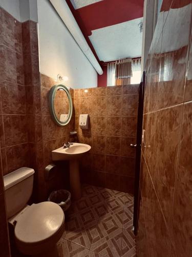 łazienka z toaletą i umywalką w obiekcie Hotel Metropolitano w mieście Loja