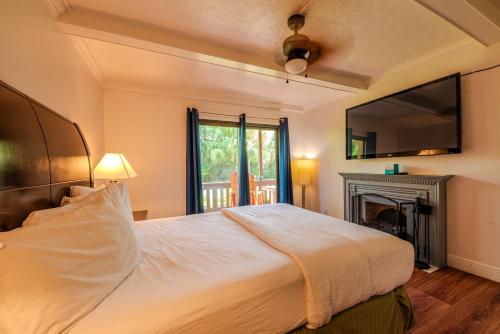 1 dormitorio con 1 cama grande y chimenea en Toucans Retreat Tranquil 1BR Condo with Patio 102, en South Padre Island