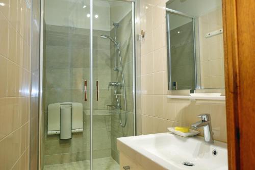 La salle de bains est pourvue d'une douche en verre et d'un lavabo. dans l'établissement Plein Sud, à Cassis