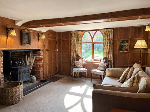 a living room with a couch and a fireplace at The Cottage Guest House in Bishops Stortford
