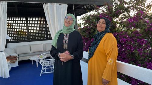 two women standing next to each other in a garden at casabonita in Asilah