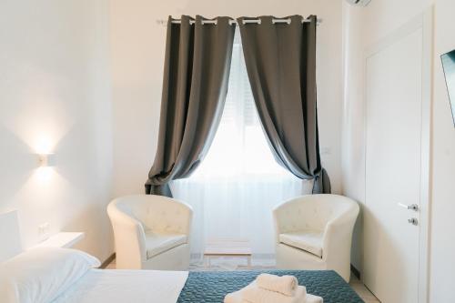 a bedroom with two chairs and a bed and a window at FG Vacanze in Alghero